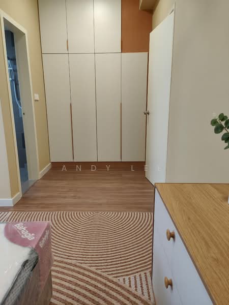 Room features: wooden flooring, built-in wardrobe with white doors, light beige painted walls, door with handle, area rug with circular pattern, wooden dresser with white drawers, neutral color scheme, wall-mounted light switch; style: modern.