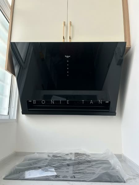 Kitchen features: black glass range hood, gold handles on cabinetry, cream upper cabinets, wood lower cabinets, grey countertop, window above sink, packaging on countertop; style: modern.