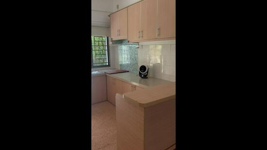 Kitchen features: light wood cabinetry, laminate countertop, white tiled backsplash, built-in oven, stainless-steel sink, single-bowl sink, window with grid design, kitchen island, appliance (unknown type), flooring with carpet texture; style: modern; view: garden.