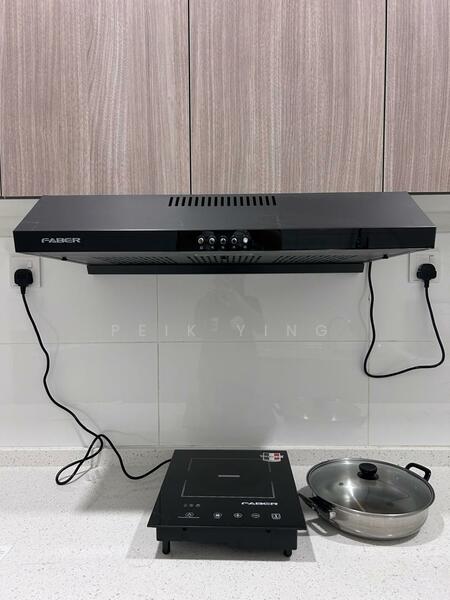 Kitchen features: black range hood, induction cooktop, stainless-steel pot, white quartz countertop, wood cabinetry with a light finish, white tiled backsplash, electrical outlets, cooking surface, modern design; style: modern.