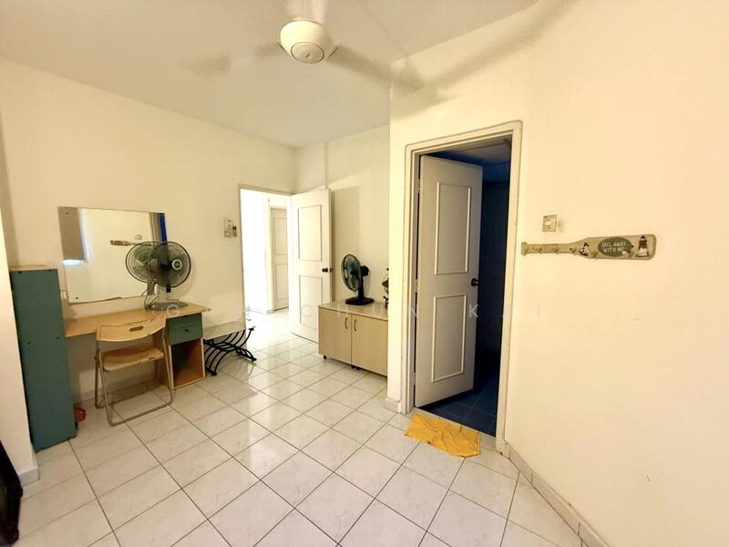 Room features: white painted walls, tile flooring, ceiling fan, mirror on wall, wooden desk, chair, two standing fans, cabinet, door leading to another room, yellow towel on floor.