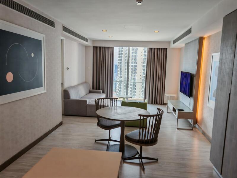 Living features: grey fabric sofa, round dining table, 2 wooden dining chairs, wall-mounted TV, TV console, floor-to-ceiling windows, curtains, light wood flooring, recessed downlights, framed artwork on wall, decorative wall paneling; style: modern; view: city.