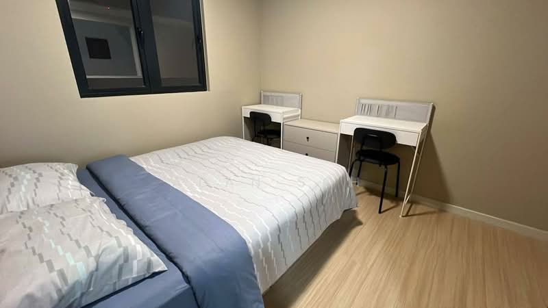 Bedroom features: queen-size bed with light grey bedding, two white bedside tables, black chairs, light wood flooring, cream painted walls, window with black frame, desk with storage drawers, mirror on desk; style: modern.