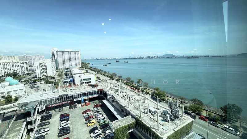 Exterior type: high-rise condominium; features: city skyline view, waterfront view, multi-storey car park, surrounded by urban landscape, visible shipping vessels, clear blue sky, manicured landscaping; style: modern.