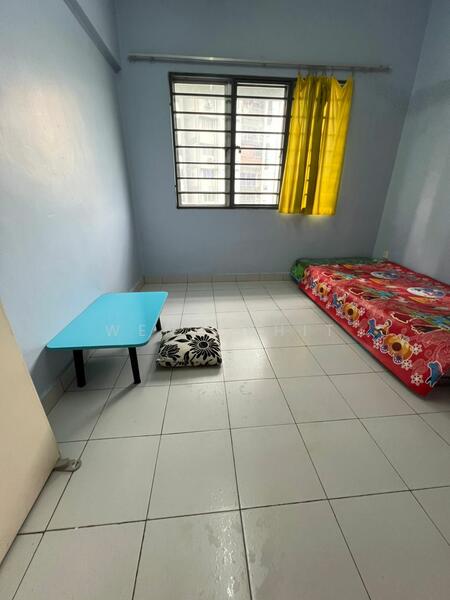 Bedroom features: light blue painted walls, white tiled flooring, single bed with floral bedding, yellow curtains, small blue table, black and white patterned cushion, window with grid, natural light from window.