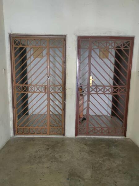 Room features: two metal security doors with diagonal bars, one door painted brown, one door painted maroon, concrete flooring, plain walls, no visible windows, minimal decor; style: minimalist.