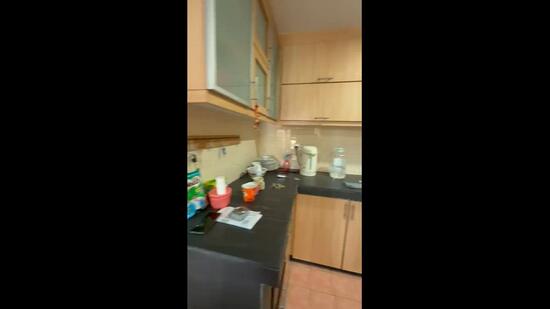 Kitchen features: light wood cabinetry, black countertop, stainless-steel sink, built-in kitchen appliances, kettle, blender, various kitchen utensils, tile backsplash, ceramic tile flooring; style: modern.