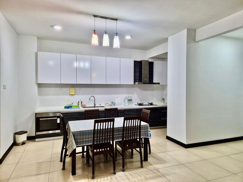 Kitchen features: white cabinets with flat-panel design, black countertop, stainless-steel sink, chrome pull-down faucet, built-in oven, 4-burner gas hob, refrigerator, dining table with 6 wooden chairs, pendant lighting with three colored bulbs, tile flooring, white walls, wall-mounted cabinets; style: modern.