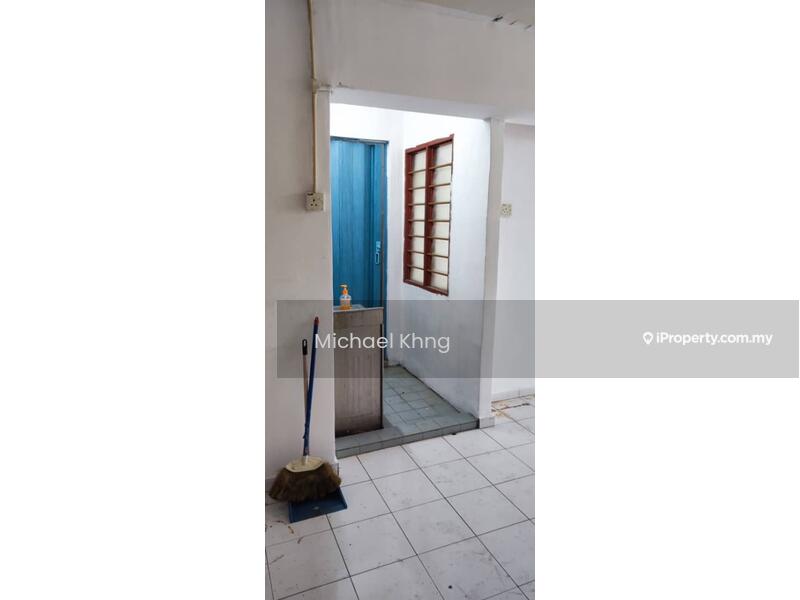Room features: white painted walls, tile flooring, blue door, window with grid pattern, cleaning broom, small entryway, light fixture on ceiling.