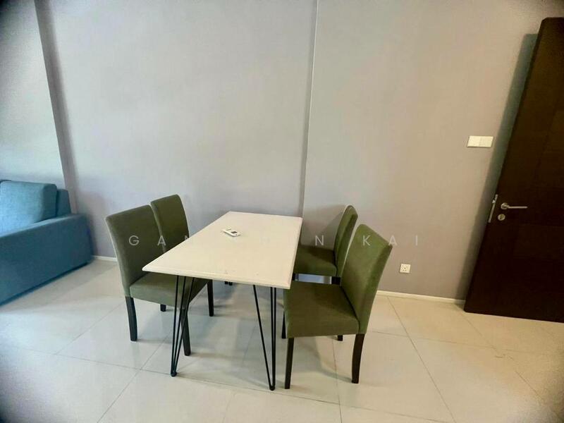 Dining features: rectangular dining table with light-colored top, four green upholstered dining chairs, grey painted walls, light-colored tile flooring, wall-mounted light switch, door leading to another room; style: modern. Living features: sofa in light blue color, neutral wall color, minimalist decor; style: modern.