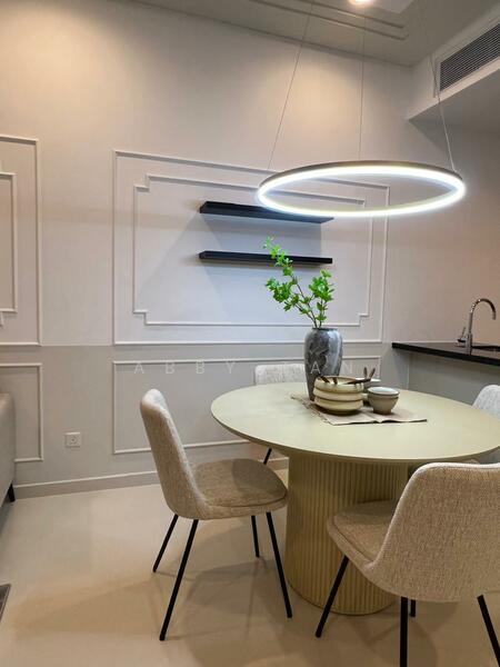 Dining features: round dining table, light-colored table with ribbed base, upholstered dining chairs, decorative vase with greenery, ceramic plates, cutlery, shelf unit on wall, recessed ceiling with crown moulding, pendant light fixture with circular design, neutral wall color, smooth flooring; style: modern.