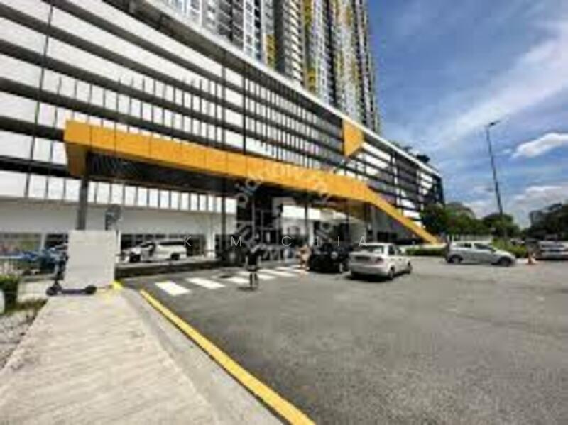 Exterior type: high-rise condominium; features: yellow accent facade, glass curtain wall, multi-storey car park, covered parking area, driveway with interlocking pavers, double-volume main lobby, surrounded by mature greenery, urban context with nearby vehicles; style: modern.