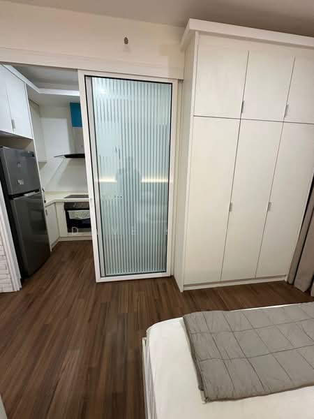 Room features: wooden flooring, white painted walls, built-in wardrobe with sliding doors, glass sliding door, stainless-steel fridge, kitchen area visible, countertop, cabinets, recessed lighting; style: modern.