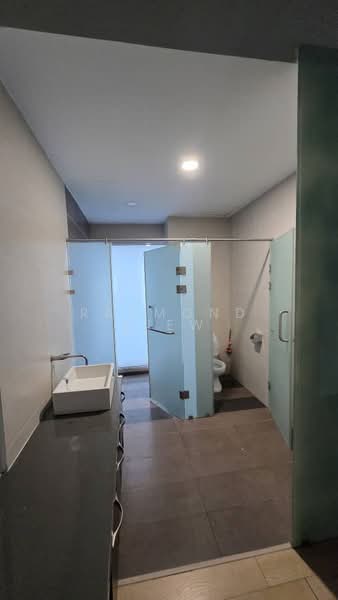 Bathroom features: single-sink vanity with white cabinet, mirror above vanity, glass shower enclosure, toilet, grey tiled flooring, light grey painted walls, recessed downlights, sliding glass door, wall-mounted towel rack; style: modern.