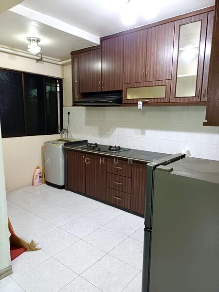 Kitchen features: brown wooden cabinetry, black countertop, stainless-steel sink, built-in gas hob, exhaust hood, white tiled backsplash, white tiled flooring, refrigerator, washing machine, window with black frame, overhead lighting; style: modern.