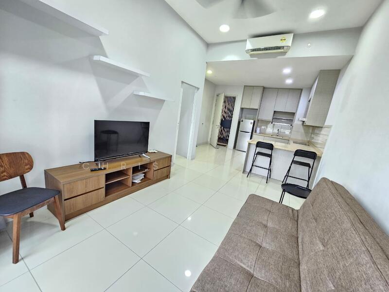 Living features: white painted walls, glossy white tile flooring, 5-blade ceiling fan, wall-mounted TV, wooden TV console, sofa bed in brown fabric, open shelving unit, two black folding chairs, kitchenette visible in background, refrigerator visible in background; style: modern.