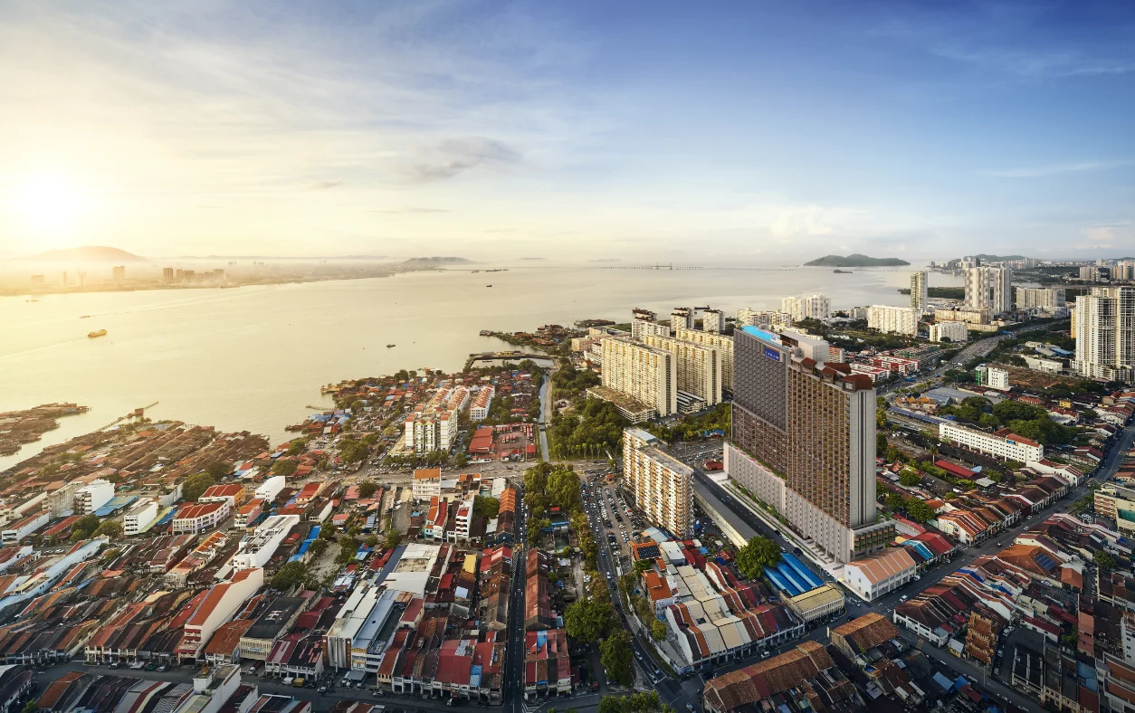 Exterior type: high-rise condominium; features: glass curtain wall, recessed balconies, surrounded by mature greenery, urban context with waterfront view, adjacent to low-rise buildings, city skyline in background; style: modern.