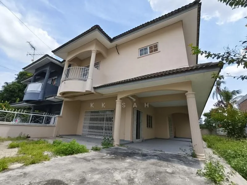 Exterior type: detached bungalow; features: cream painted facade, flat roof, two-storey building, balcony with railing on upper floor, covered porch area, driveway with concrete surface, manicured lawn area, surrounded by greenery, visible windows on upper and lower floors, gated entrance; style: modern.