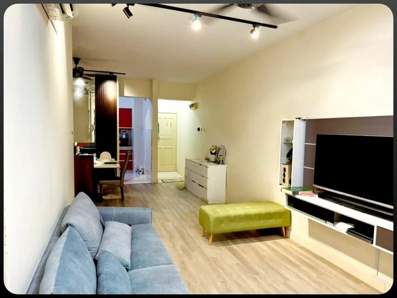 Living features: 3-seater fabric sofa in light blue, green upholstered bench, wall-mounted TV, TV console with storage, wooden flooring, recessed LED downlights, ceiling fan, open layout to kitchen, decorative wall shelf; style: modern. Kitchen features: kitchen island with seating, stainless-steel sink, built-in cabinets, refrigerator visible in background, wall-mounted microwave, countertop with bar stools; style: modern.