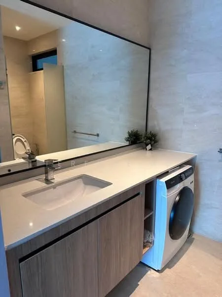 Bathroom features: single-sink vanity with wood cabinet, white countertop, mirror above vanity, built-in washing machine, light-colored wall tiles, recessed downlights, towel bar, toilet, plant decor; style: modern.