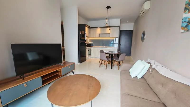 Living features: 3-seater fabric sofa in beige, coffee table with round top, TV console with storage, wall-mounted TV, pendant lighting, recessed LED downlights, floor-to-ceiling windows, air conditioning unit, decorative wall art; style: modern. Kitchen features: kitchen island with seating, stainless-steel fridge, built-in oven, freestanding range oven, ceramic tile backsplash, white cabinetry, quartz countertop, recessed lighting; style: modern.