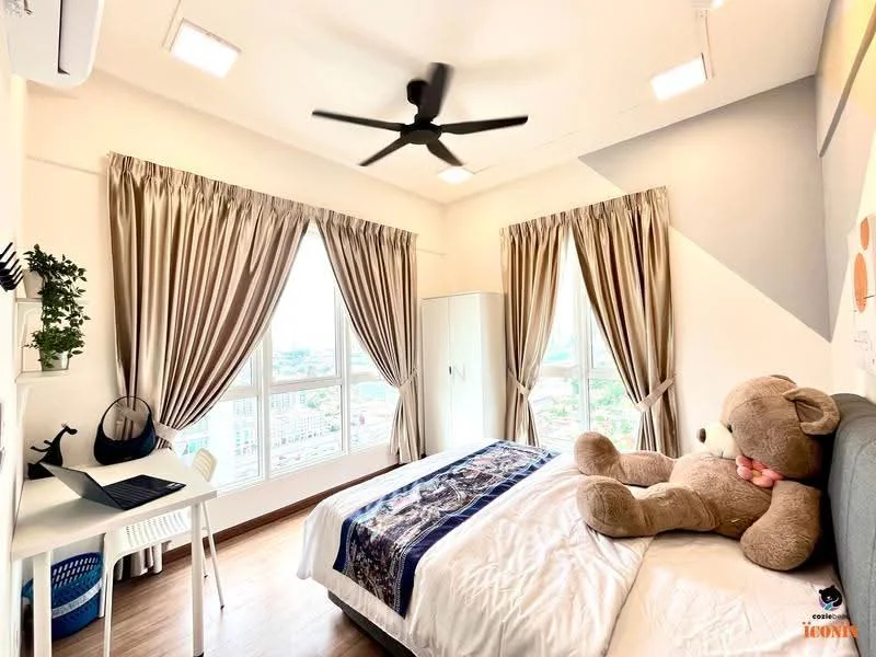 Bedroom features: queen-size bed with white bedding, upholstered headboard, 3-blade ceiling fan, floor-to-ceiling windows, curtains in beige, wooden flooring, study desk with chair, decorative teddy bear, white wardrobe, wall-mounted artwork, decorative plant on desk; style: modern; view: city.