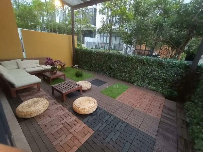 Room features: outdoor seating area, sectional sofa with cushions, wooden coffee table, woven poufs, paved flooring with wooden and tile patterns, greenery with hedges, decorative plants, artificial grass patches; style: modern; view: garden.