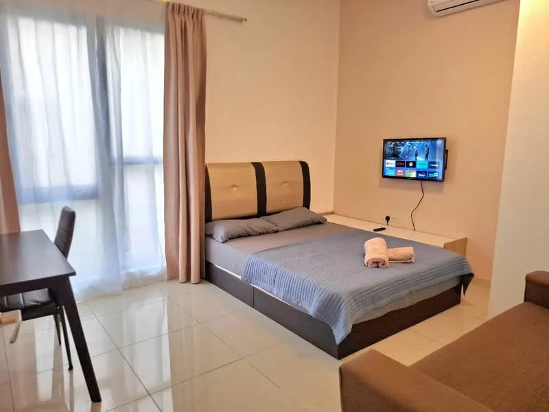 Bedroom features: queen-size bed with upholstered headboard, grey bedding, 2 bedside towels, wall-mounted TV, wooden dining table with 2 chairs, sofa, floor-to-ceiling windows with sheer curtains, white painted walls, glossy tile flooring, wall-mounted air conditioning unit; style: modern.