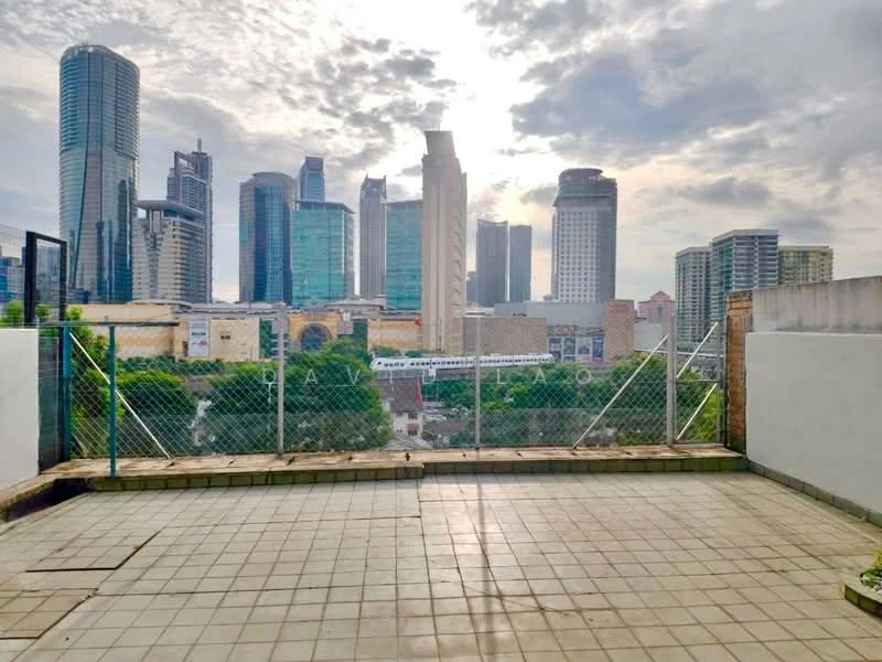 Exterior features: city skyline view, fenced terrace area, paved flooring, surrounding greenery, high-rise buildings in background, partially cloudy sky; style: modern.