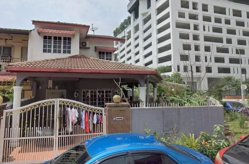 Exterior type: semi-detached house; features: red tiled roof, white painted facade, front gate with decorative design, manicured garden, laundry hanging on the fence, stone wall, paved driveway, surrounding greenery, two-storey structure, balcony with railing; style: traditional.
