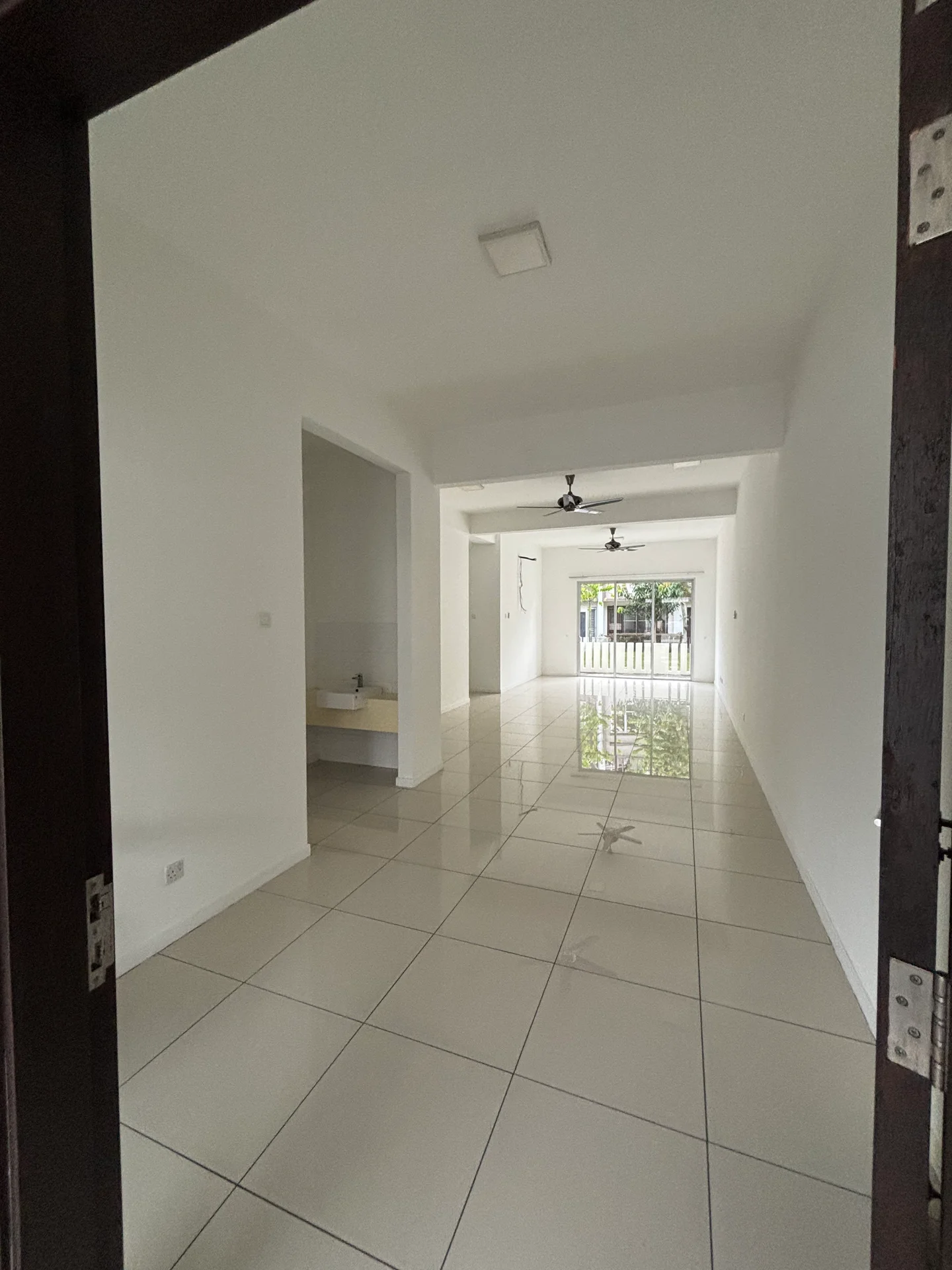 Room features: white painted walls, glossy ceramic tile flooring, recessed downlights, 2 ceiling fans, large sliding glass door, window with view to exterior, open layout, utility area visible; style: modern; view: garden.