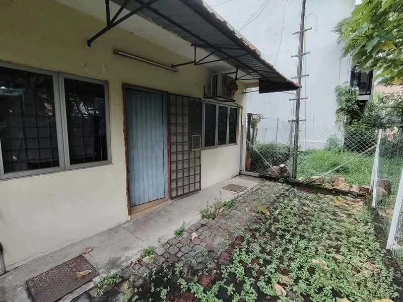 Exterior type: detached bungalow; features: single-storey, sliding glass door, gravel pathway, manicured lawn, fenced yard, overhanging roof, window grilles, exposed concrete wall, mature greenery; style: traditional.
