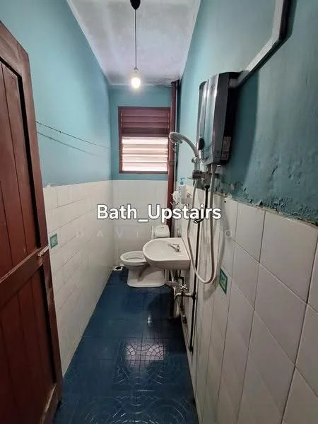 Bathroom features: blue painted walls, white tiled walls, blue ceramic tile flooring, single-sink vanity with wall-mounted faucet, one-piece toilet, shower with handheld showerhead, water heater, window with wooden slats, light fixture, wooden door.
