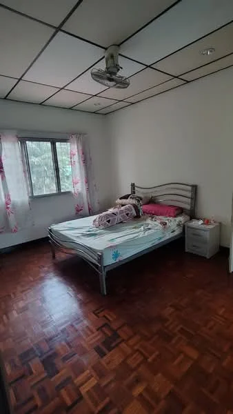 Bedroom features: wooden parquet flooring, white painted walls, ceiling-mounted projector, single bed with floral bedding, nightstand with drawer, curtains with floral pattern, window with view of greenery, light fixture on ceiling; view: garden.