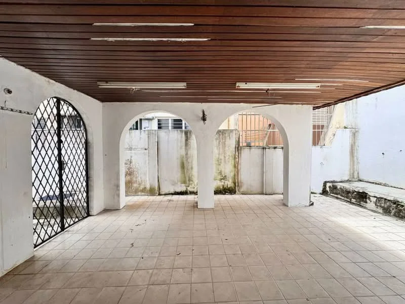 Room features: tiled flooring, white painted walls, wooden ceiling, arched openings, metal security gate, exposed concrete wall, fluorescent ceiling lights.