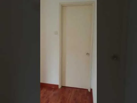 Room features: plain white walls, wood laminate flooring, single door, light switch, neutral color scheme.