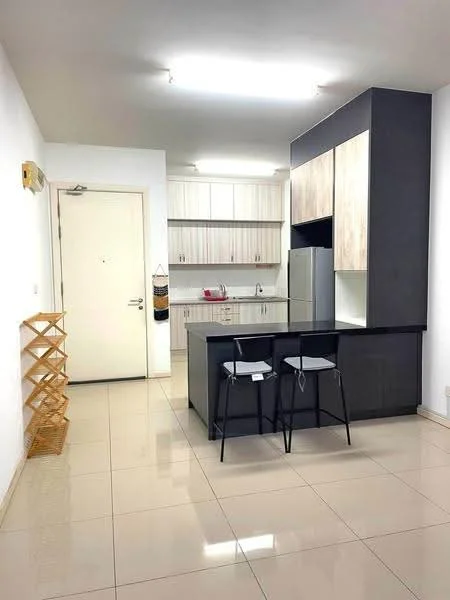 Kitchen features: white painted walls, glossy beige tile flooring, black countertop, wood cabinetry with light finish, stainless-steel fridge, built-in kitchen cabinets, two bar stools, open shelving unit, recessed ceiling lights; style: modern.