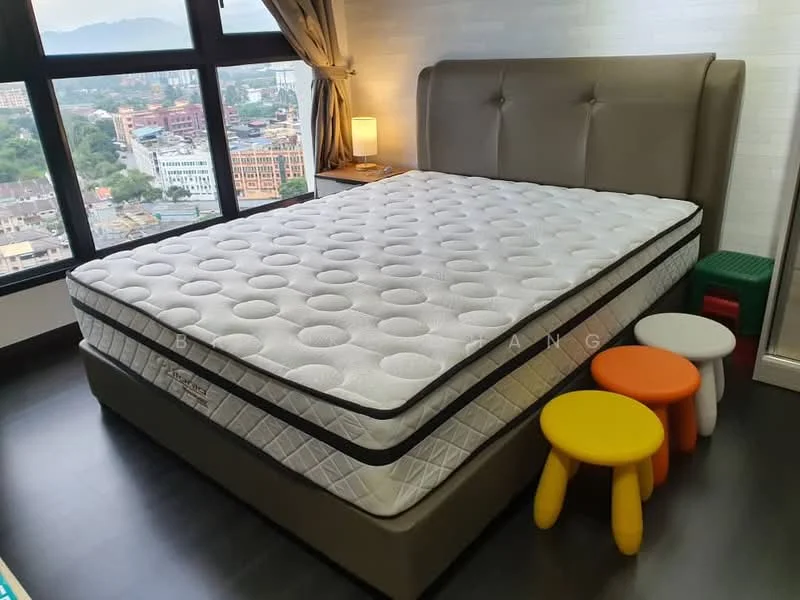 Bedroom features: king-size bed, upholstered headboard in beige, white mattress with quilted pattern, bedside lamp on nightstand, floor-to-ceiling window with city view, dark wood flooring, colorful children's stools in red, green, and orange, decorative curtains, wall-mounted artwork, light-colored accent wall; style: modern; view: city.