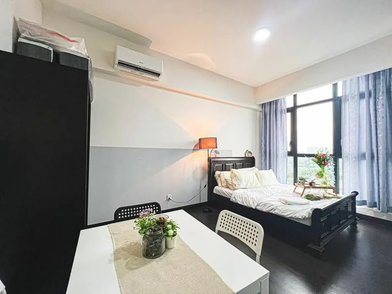 Bedroom features: queen-size bed with white bedding, black wooden bed frame, floor-to-ceiling windows, light blue sheer curtains, dark wood flooring, 1 wall-mounted split AC, table lamp with warm light, small dining table with white chairs, decorative plants on table, black storage cabinet, wall-mounted shelving unit; style: modern; view: city.