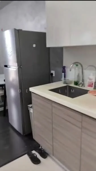 Kitchen features: grey stainless-steel fridge, single-bowl stainless-steel sink, chrome pull-down faucet, light-colored countertop, flat-panel cabinetry in light wood, dark flooring, dish soap bottle, cleaning supplies, kitchen towel, slippers on the floor; style: modern.