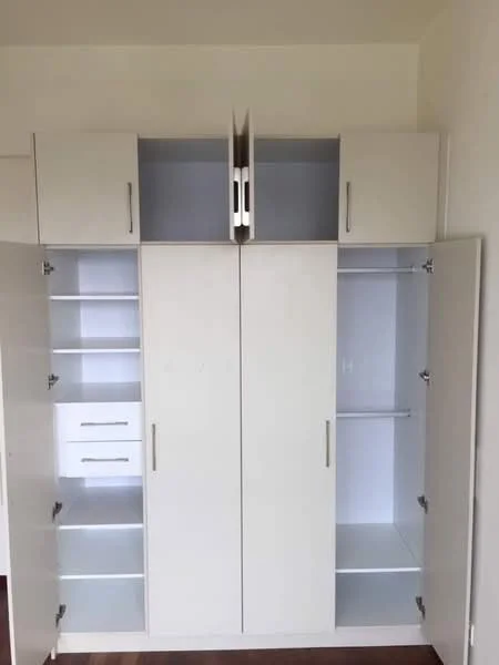 Room features: built-in wardrobe with white finish, two double doors, two upper cabinets, one drawer, open shelving, minimalist design, metal handles; style: modern.