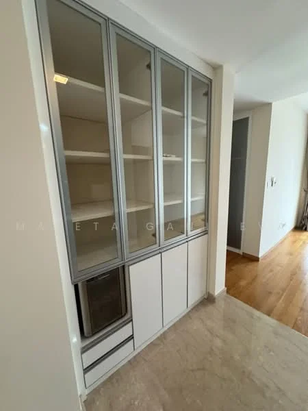 Room features: built-in cabinetry with glass doors, white cabinetry with silver trim, open shelving, lower cabinets with drawers, marble flooring, neutral wall color, refrigerator visible, light source above cabinetry; style: modern.