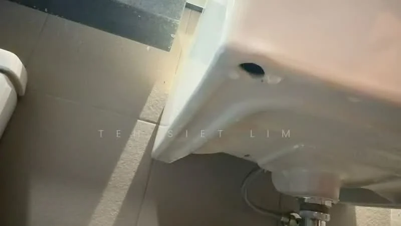 Bathroom features: white ceramic toilet, white ceramic sink, chrome faucet, grey tiled flooring, light beige wall tiles, visible plumbing, sink mounted on wall, toilet positioned next to sink; style: modern.
