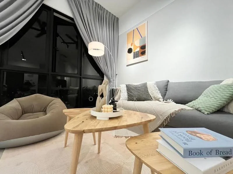 Living features: grey fabric sofa, wooden coffee table, beige bean bag chair, decorative throw pillows, framed artwork on wall, floor lamp with white shade, curtains in light grey, area rug with geometric pattern, books stacked on table; style: modern.