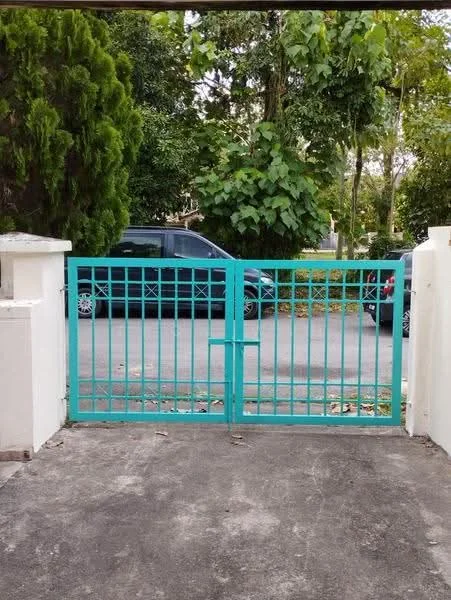 Exterior features: turquoise metal gate, concrete driveway, surrounded by greenery, paved walkway, visible street, parked vehicles; style: modern.