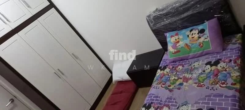 Bedroom features: single bed with colorful bedding featuring cartoon characters, wooden headboard, built-in wardrobe with white doors, wooden flooring, decorative throw pillow, wall-mounted artwork, window with no visible treatment.