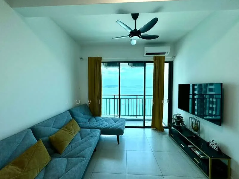 Living features: grey fabric L-shape sectional sofa, yellow accent cushions, wall-mounted flat-screen TV, black TV console, floor-to-ceiling windows, sliding glass door, sheer curtains, 5-blade ceiling fan with light, white painted walls, tile flooring, ocean view; style: modern; view: sea.