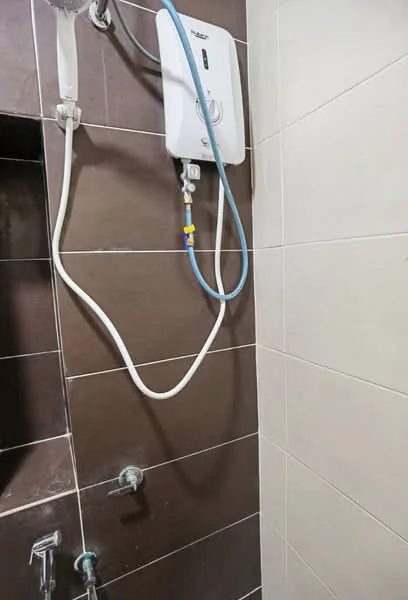 Bathroom features: brown tiled walls, white shower head, wall-mounted water heater, chrome faucet, tile cladding, shower hose, ceramic tile flooring; style: modern.