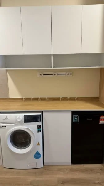 Laundry features: white front-load washing machine, black fridge, wood countertop, white cabinetry above countertop, light beige wall, light wood flooring; style: modern.