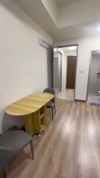 Room features: light wood laminate flooring, cream painted walls, 1 round wooden table, 2 grey upholstered chairs, wall-mounted air conditioning unit, doorway leading to bathroom, doorway leading to hallway, recessed ceiling lights; style: modern.